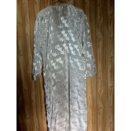Robe Longue Blanche. Cousue Main. Tissu Satiné, Motif Feuilles. Plastron Devant Travaillé (Lourd). Fente Devant De 30 Cm Environ Largeur Taille : 65 M. Longueur : 1,42 M Environ. D'occasion : Très Bon