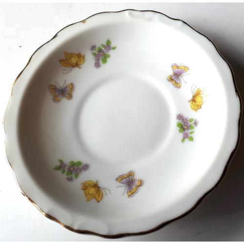 Petite assiette décorative en porcelaine blanche au contour crénelé souligné de doré et avec de délicats motifs de papillons et fleurs répartis en 3 groupes au pourtour-diamètre 10cm