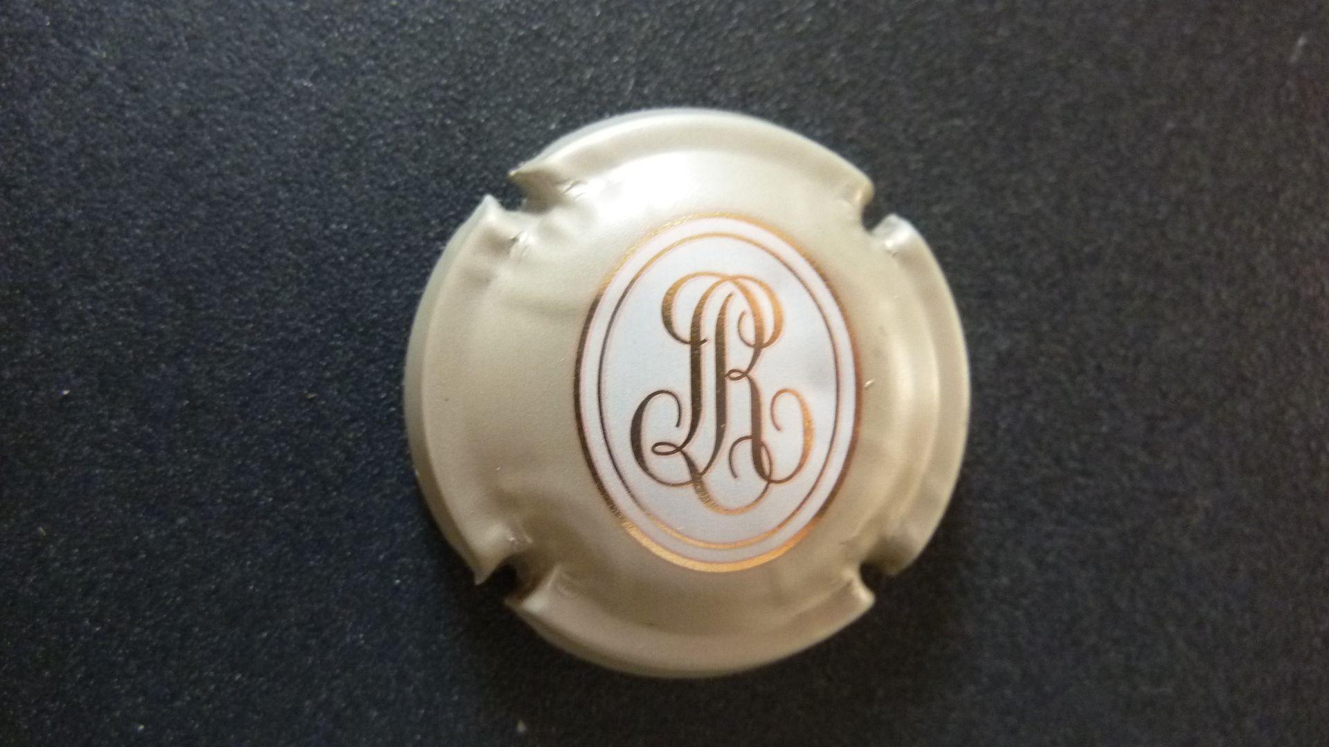 capsule de champagne = lettre L R ( Louis ROEDERER ), dorée dans médaillon  et muselet gris beige
