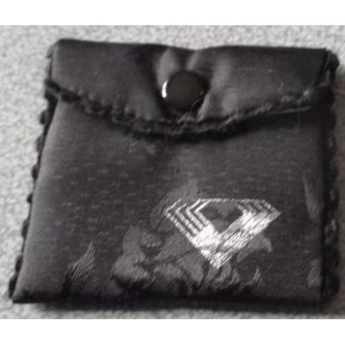Pochette tissu noir avec impression de feuillage un peu brillant et dessin d'un petit logo en forme de diamant - bords festonnés - doublée de tissu synthétique blanc - fermeture par pression 6.5x6.5cm