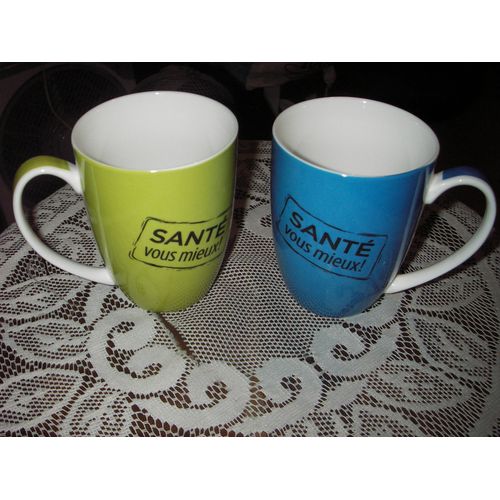 Lot De 2 Mugs À Hanse " Santé Vous Mieux "De Marque Suprapharm, L'un Coloris Vert Et Blanc, L'autre Bleu Et Blanc, Inscription " Santé Vous Mieux " Noir, Fond Intérieur Blanc.