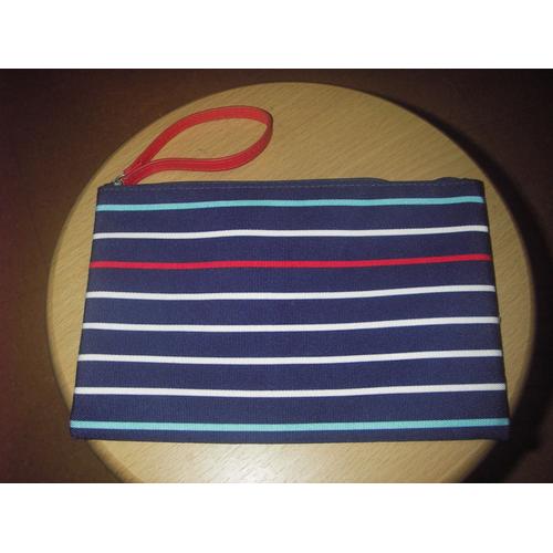 Pochette zippée à rayures multicolores ( bleu clair, blanc, rouge ) sur fond bleu marine Design By, poche unique entièrement doublée nylon bleu, languette zippe en simili cuir rouge.