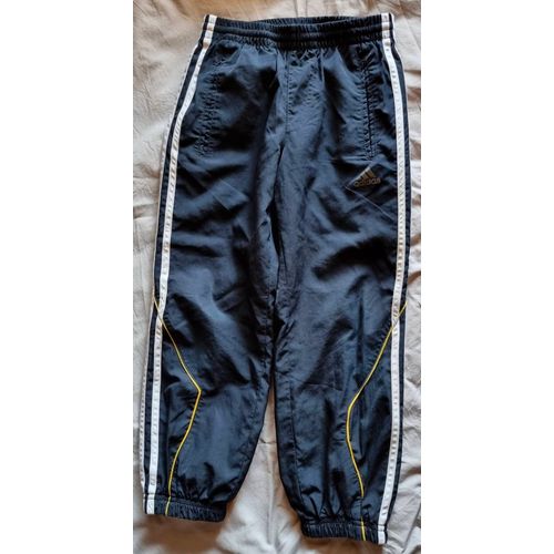 Pantalon De Jogging Garçon 6 Ans. Marque Adidas. Noir. Avec Bandes Blanches Sur Le Côté Extérieur Et 1 Liseret Jaune. Polyester Fin
