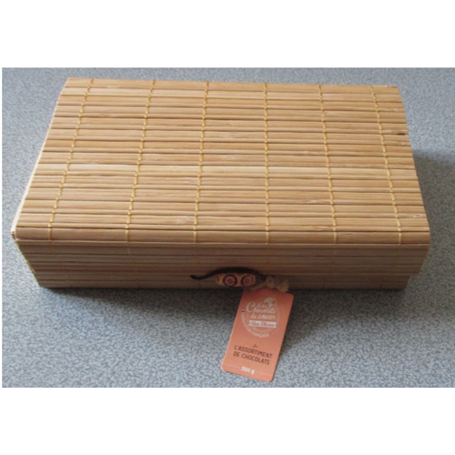 Coffret imitation paille tressée-côtés bois et inscription Les Chocolats Du Coeur-couvercle souple-fermoir décoré s'accrochant par élastique-garni de papier hachuré-pour ranger des petits trésors