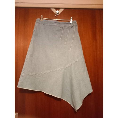 Jupe Mi-Longue Asymétrique En Jean Quartz, Taille 38, Coloris Bleu Clair, 3 Bandes En Biais En Surpiqûres Sur L'un Des Cotés De La Jupe Sur Le Haut À L'avant, Fermeture Zippée Sur Le Coté Gauche.