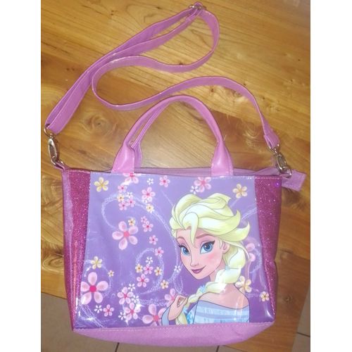 Sac à mains Reine des Neiges (Elsa). Modèle avec bandoulière et poignées sur le dessus en polyester. Doublure 100% polyester. Dimensions approximatives : 8*17*26 cm.