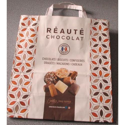 Sac papier publicitaire Réauté Chocolat- fond blanc avec images de gateaux et chocolats Goutez vous verrez- cotés décorés arabesques- 22.5x24x10cm- 2 anses de portage