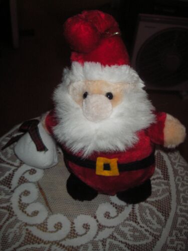 Peluche Père Noël Avec Son Sac À Cadeau À La Main À Accrocher, Nez Pompon, Yeux Billes, Ceinture Velours Noir, Boucle Feutrine Jaune, Sac En Tissu Blanc Fermé Par Un Ruban Écossais.