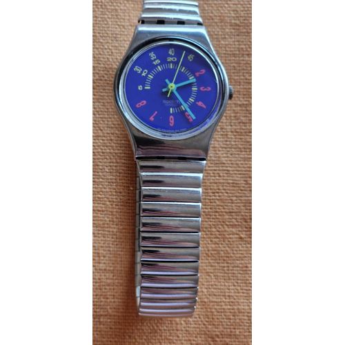 Montre Femme Marque Swatch, Bracelet Acier De 1,2 Cm, Écran 2 Cm Avec Fond Bleu-Violet. État Impeccable, En État De Marche.