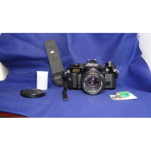 Canon ae-1 program + Objectif 50 mm 1:1.8 + 1 pellicule 35 mm et 1 pile ainsi qu'une sangle de cou