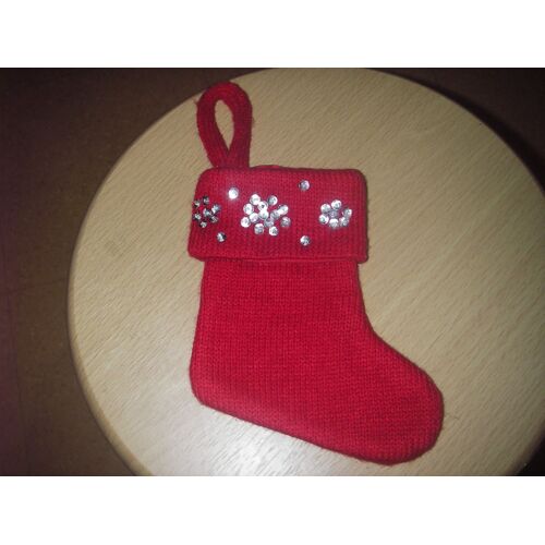 Petite chaussette de Noël à accrocher, coloris rouge, flocon de neige en paillettes argentées cousues sur le rebord à l'avant, extérieur 100% acrylique, doublure 100% polyester, hauteur 23,5 cm.