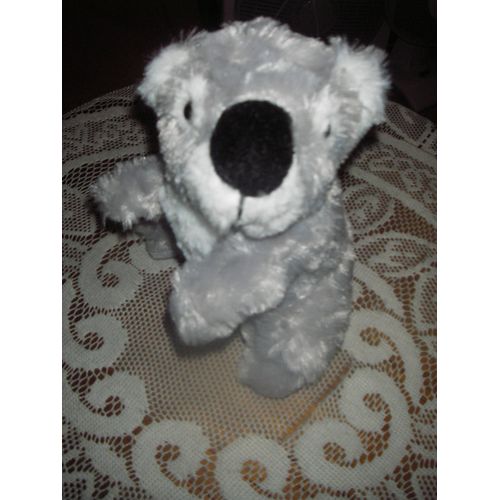 Peluche Koala Blanche Porte ,Yeux Billes ,Museau Et Dessous De Pattes Feutrine ,Bouche Brodée ,Coloris Gris Et Blanc,100% Polyester ,Dimensions :Hauteur 15 Cm ,Largeur 12 Cm ,Profondeur 10 Cm .