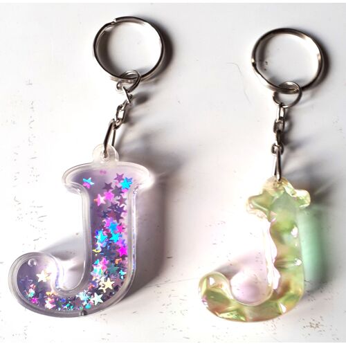 Porte-Clés Lettre J En Plastique Incolore À L'intérieur De Laquelle Circulent Des Mini Étoiles Scintillantes Bleutées Et Argentées + Lettre J En Plastique Incolore Formé De Facettes À L'aspect Irisé