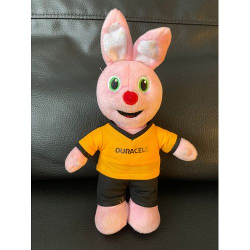 Peluche doudou Lapin souriant orange et sa pile au dos Duracell 23 cm