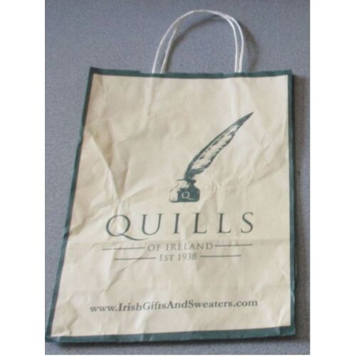 Sac papier publicitaire aux couleurs de Quills Ireland jaune et vert avec dessin d'une plume dans son encrier-magasins de souvenirs et vêtements typiquement irlandais-2 anses de portage-22x29.5x9.5cm