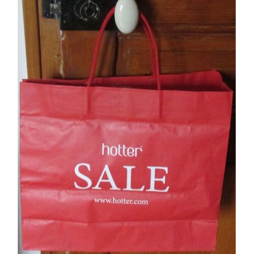 Sac papier publicitaire Hotter-fond rouge-2 anses de portage-40x35x14cm-100% recyclable et utilement réutilisable-vient d'un magasin de chaussures d'Angleterre