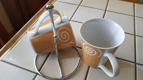 Ensemble 2 Tasses En Porcelaine Identiques Beiges Et Blanches Motif Rond Circulaire Blanc Avec Support De Pose 2 Branches Argenté En Acier.
