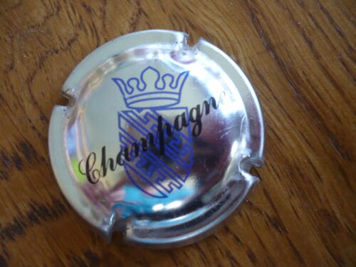 Capsule Champagne Ecusson Bleu Sur Fond Métal Argenté