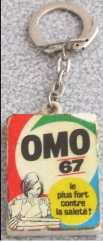 Porte-Clés Ancien Pour La Lessive Omo 67 Le Plus Fort Contre La Saleté - Pas Très Bien Conservé Mais Pour Le Souvenir Publicitaire