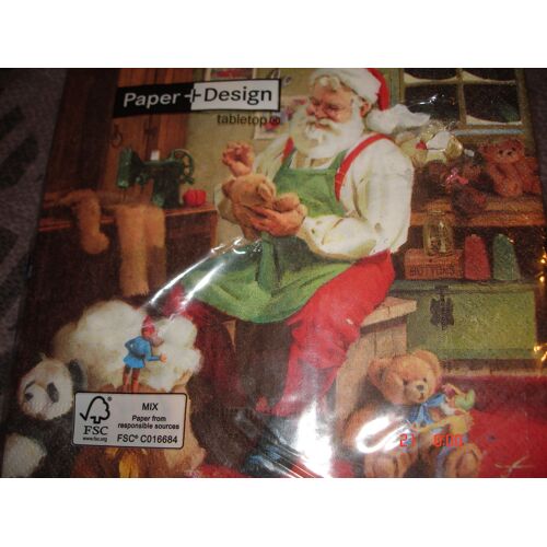 Serviette en papier décor Père Noël confectionnant des cadeaux dans son atelier