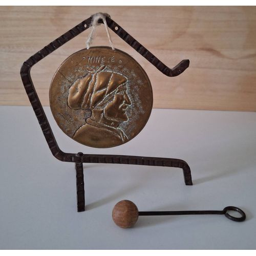 Gong vintage en métal suspendu sur un support en fer forgé et le maillet