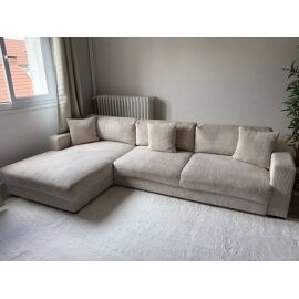 Canapé d¿angle en velour côtelé beige convertible avec coffre de rangement.