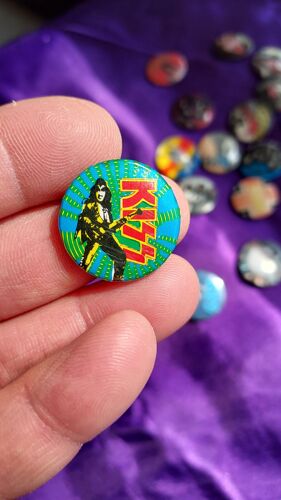 Kiss. Badge Rond Avec Gene Live Années '70 Sur Fond Bleu Et Vert Avec Le Logo Rouge Et Jaune À Sa Droite. 2.5 Cm. Badge Du Début Des Années 80 En Excellent État. Lot 49