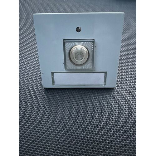 bouton poussoir de sonnette ou d’interphone ancien avec porte-étiquette intégré.